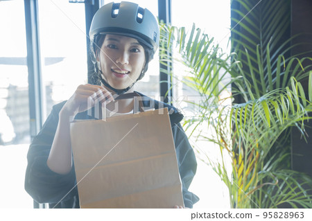 Female delivery worker delivering food delivery Female delivery worker delivering food delivery 95828963