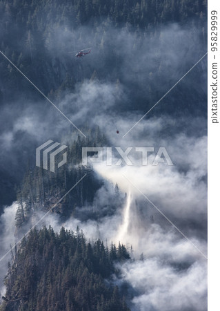 Wildfire Service Helicopter flying over BC Forest Fire and Smoke on the mountain near Hope 95829999