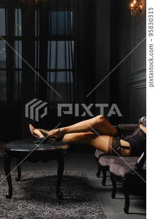 Low key photo of female legs in stockings with suspender belt Low key photo of female legs in stockings with suspender belt 95830315
