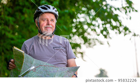 Smiling active senior man cycling or biking outside, choosing or selects the trip using the map, healthy lifestyle sport concept Smiling active senior man cycling or biking outside, choosing or selects the trip using the map, healthy lifestyle sport concept 95832226