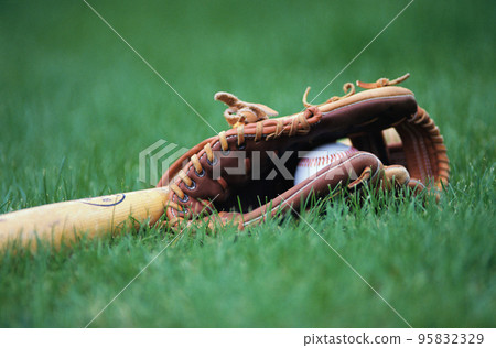 Old baseball, glove, and bat on field 95832329