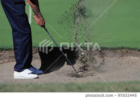 Male golfer about to hit out of a sand bunker Male golfer about to hit out of a sand bunker 95832448