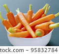 Fresh organic honey glazed baby carrots in a serving bowl 95832784