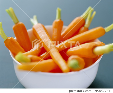 Fresh organic honey glazed baby carrots in a serving bowl 95832784