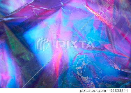 Transparent holographic wrinkled polyethylene background. Holographic colorful plastic film in blue, purple and pink tones with copy space. High quality photo 95833244
