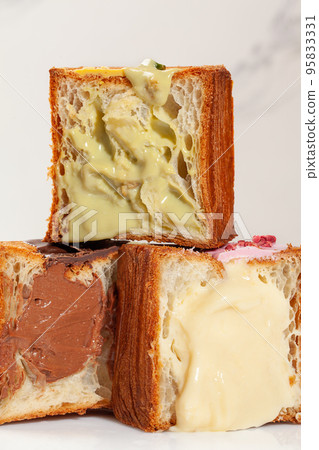 Pyramid of halves of cube croissants with pistachio cream, vanilla custard and chocolate filling 95833331
