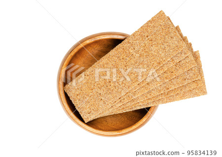 Thin slices of sourdough whole grain rye crispbread, in a wooden bowl. Rectangle shaped, flat and dry, crunchy and crisp cracker and light bread. Close-up, from above, isolated over white, food photo. Thin slices of sourdough whole grain rye crispbread, in a wooden bowl. Rectangle shaped, flat and dry, crunchy and crisp cracker and light bread. Close-up, from above, isolated over white, food photo. 95834139