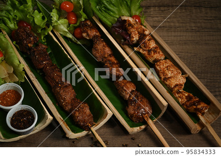 Delicious grilled meat served in bamboo barrel plat. Mala Chinese BBQ is meat or vegetable grilled with Chinese hot and spicy spices Delicious grilled meat served in bamboo barrel plat. Mala Chinese BBQ is meat or vegetable grilled with Chinese hot and spicy spices 95834333