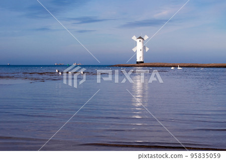 Old windmill lighthouse in Swinoujscie, a port in Poland on the Baltic Sea. 95835059