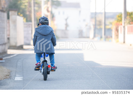 Asian kid riding a bicycle in winter Asian kid riding a bicycle in winter 95835374