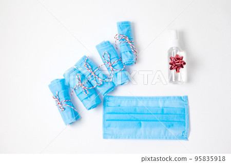 Photo of christmas gifts. Medical masks and antiseptic 95835918