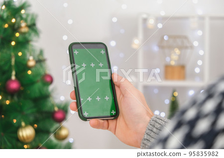 A man holds a phone in an upright position with a A man holds a phone in an upright position with a 95835982