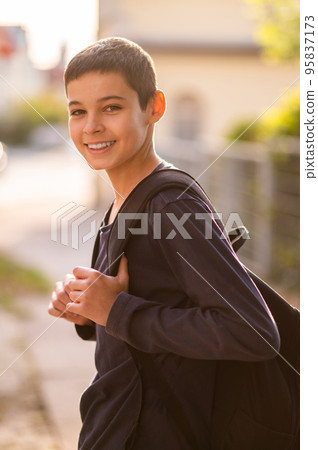 Joyful adolescent boy with the rucksack outdoors 95837173