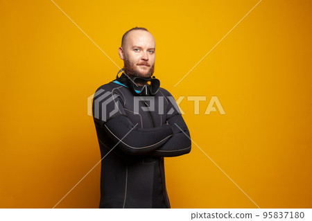 Portrait of diver man with crossed arms on yellow background Portrait of diver man with crossed arms on yellow background 95837180