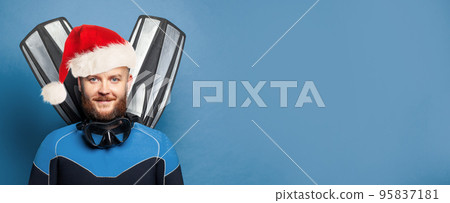 Cheerful man diver Santa smiling on blue background Cheerful man diver Santa smiling on blue background 95837181