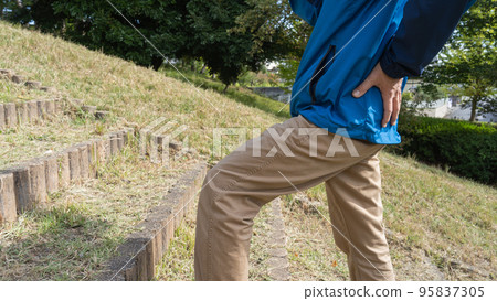 一個男人在樓梯上呼吸急促和背痛的形象 95837305