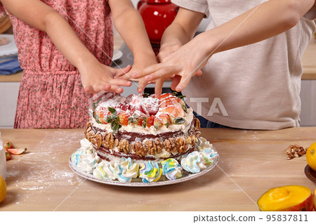 Little friends are making a cake together at a kitchen. Little friends are making a cake together at a kitchen. 95837811
