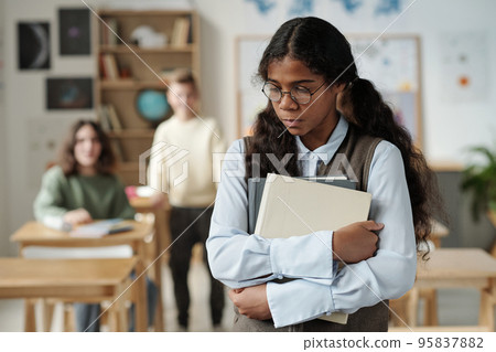 Offended secondary school pupil with books standing in front of camera Offended secondary school pupil with books standing in front of camera 95837882