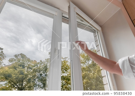 woman hand open pvc window with double glazing. Room ventilation concept woman hand open pvc window with double glazing. Room ventilation concept 95838430