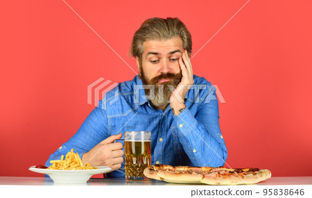 Bad appetite. Bored and sad. Beer and food. Dinner at pub. Hungry man going to eat pizza french fries and drink beer. Pizzeria restaurant. Upset man bearded hipster eat pizza. Pizza party concept 95838646