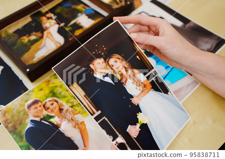 printed wedding photos in the hands and in a wooden box with a flash drive. printed wedding photos in the hands and in a wooden box with a flash drive. 95838711
