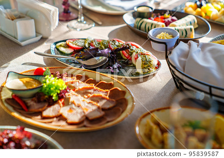salads and cold cuts. a table served with utensils and snacks for lunch. 95839587