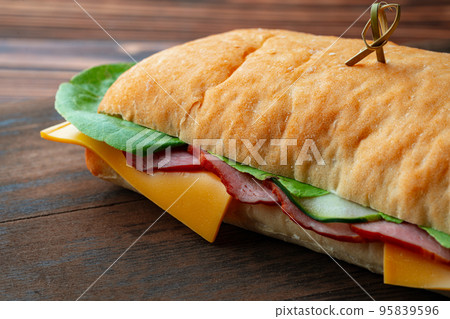 Ham sandwich with cheese and lettuce on table Ham sandwich with cheese and lettuce on table 95839596