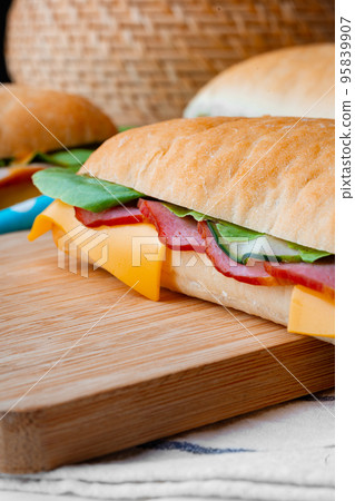 Sandwich with ham and cheese on wooden board 95839907