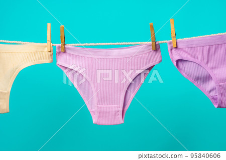 Female panties hanging on rope against blue studio background Female panties hanging on rope against blue studio background 95840606
