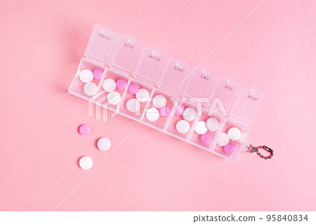Beautiful closeup of tablet vitamin for women on pink background . Medical healthcare pillbox for a week. Medicine medical health. Beautiful closeup of tablet vitamin for women on pink background . Medical healthcare pillbox for a week. Medicine medical health. 95840834