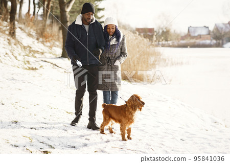 People walks outside. Winter day. African couple with dog. People walks outside. Winter day. African couple with dog. 95841036