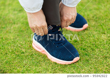 系跑鞋鞋帶的中高級女性 95842822