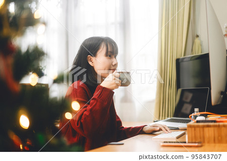Young adult asian woman sipping a coffee using computer for trade crypto currency. Young adult asian woman sipping a coffee using computer for trade crypto currency. 95843707