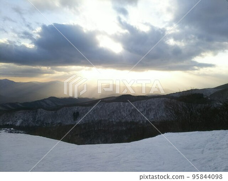 Light pouring down from the mountains in winter 95844098