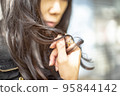 一個女人的手撫摸她的深色長發的特寫 95844142