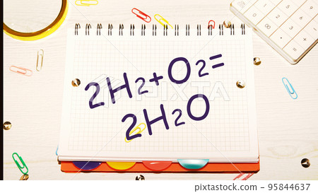 Reaction of Hydrogen (H2) and Oxygen (O2) to Water text on a notebook sheet on the desktop next to office supplies Reaction of Hydrogen (H2) and Oxygen (O2) to Water text on a notebook sheet on the desktop next to office supplies 95844637