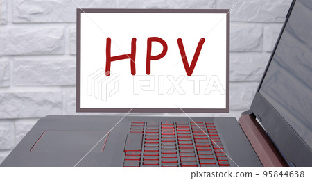 HPV text on a magnetic board on a brick decorative wall next to a laptop 95844638