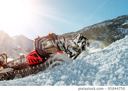 Red modern snowcat ratrack with snowplow snow grooming machine preparing ski slope piste hill at alpine skiing winter resort Ischgl in Austria. Heavy machinery mountain equipment track vehicle Red modern snowcat ratrack with snowplow snow grooming machine preparing ski slope piste hill at alpine skiing winter resort Ischgl in Austria. Heavy machinery mountain equipment track vehicle 95844750