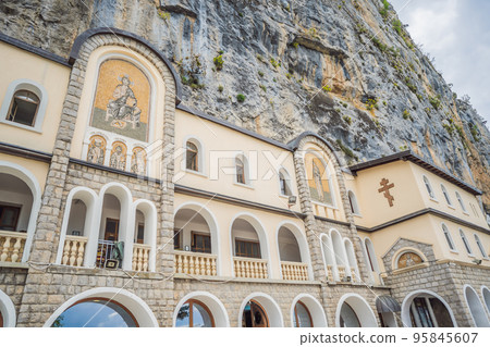 Monastery of Ostrog, Serbian Orthodox Church situated against a vertical background, high up in the large rock of Ostroska Greda, Montenegro. Dedicated to Saint Basil of Ostrog 95845607
