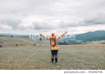 Hipster tourist woman with backpack and sleeping bag walks in the mountains in summer at sunset The girl travels to beautiful places. Mock up for text message. Hipster tourist woman with backpack and sleeping bag walks in the mountains in summer at sunset The girl travels to beautiful places. Mock up for text message. 95846746