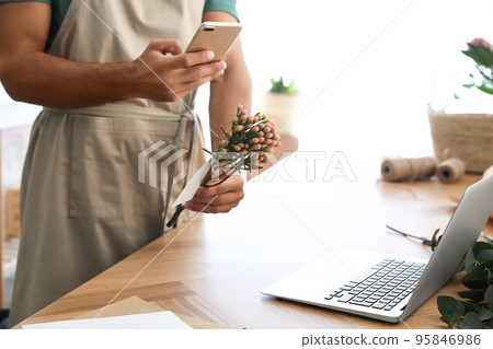 Florist taking picture of brunia flower in workshop, closeup Florist taking picture of brunia flower in workshop, closeup 95846986