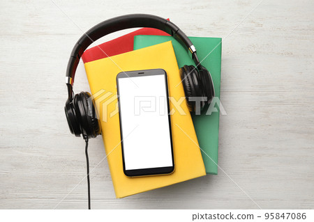 Books with modern headphones and smartphone on white wooden background, top view. Space for design Books with modern headphones and smartphone on white wooden background, top view. Space for design 95847086