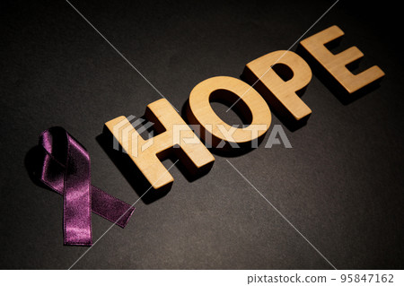 Purple ribbon and word HOPE on black background. Domestic violence awareness 95847162