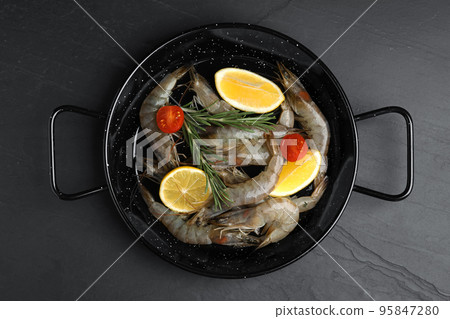 Fresh raw shrimps with lemon slices on black table, top view Fresh raw shrimps with lemon slices on black table, top view 95847280