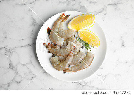Fresh raw shrimps with lemon and rosemary on marble table, top view Fresh raw shrimps with lemon and rosemary on marble table, top view 95847282