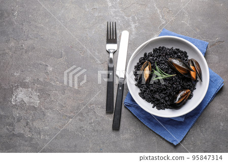 Delicious black risotto with seafood on grey table, flat lay. Space for text 95847314