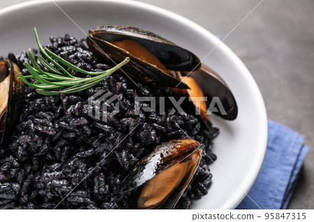 Delicious black risotto with seafood in bowl on table, closeup 95847315