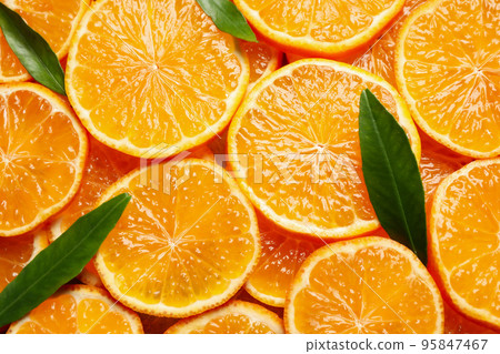 Slices of fresh ripe tangerines and leaves as background, top view. Citrus fruit Slices of fresh ripe tangerines and leaves as background, top view. Citrus fruit 95847467