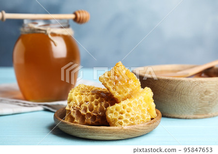 Fresh delicious honeycombs on light blue wooden table Fresh delicious honeycombs on light blue wooden table 95847653