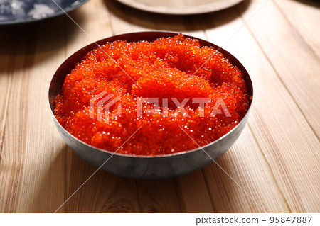 Fresh red caviar in bowl on wooden table 95847887